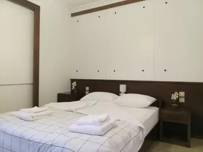 a bedroom with a large white bed with towels on it at 2BD apartment with large balcony near the sea!! in Athens