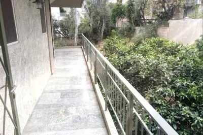 a walkway leading up to a building with bushes at 2BD apartment with large balcony near the sea!! in Athens