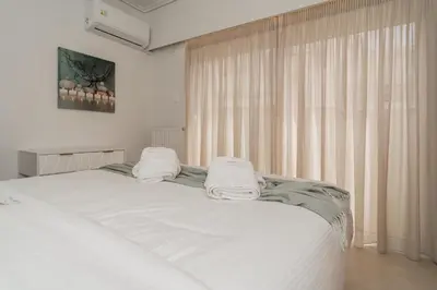 a bedroom with a white bed with two towels on it at Elegant Suite - Koukaki in Athens