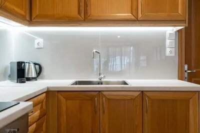 a kitchen with a sink and wooden cabinets at Elegant Suite - Koukaki in Athens