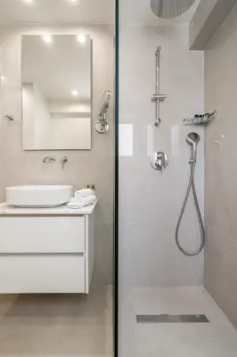 a white bathroom with a shower and a sink at Elegant Suite - Koukaki in Athens