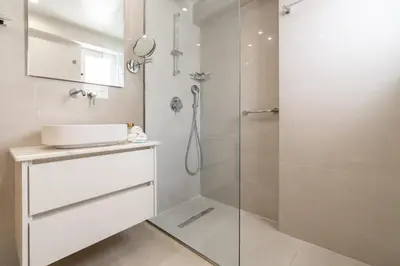 a white bathroom with a shower and a sink at Elegant Suite - Koukaki in Athens
