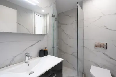 a white bathroom with a sink and a shower at Upscale Apartment in Chalandri with Large Terrace in Athens