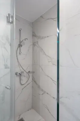 a bathroom with a shower with a glass door at Upscale Apartment in Chalandri with Large Terrace in Athens