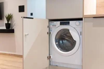 a washing machine in a kitchen with white cabinets at Upscale Apartment in Chalandri with Large Terrace in Athens