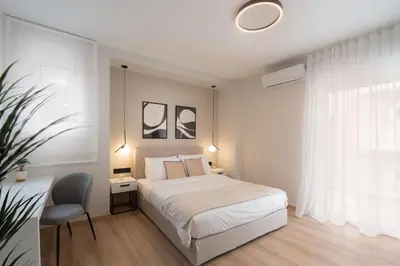 a bedroom with a bed and a chair and a window at Upscale Apartment in Chalandri with Large Terrace in Athens