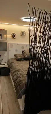 a bedroom with a bed with a black metal wall at Homeyfeel StayTOP - ΑΡΓΥΡΟΥΠΟΛΗ - ΕΛΛΗΝΙΚΟ in Athens