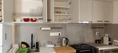 a kitchen with white cabinets and a counter top at Homeyfeel StayTOP - ΑΡΓΥΡΟΥΠΟΛΗ - ΕΛΛΗΝΙΚΟ in Athens