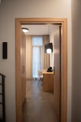 a hallway with a door leading to a room with a desk at Evia Hotel in Athens