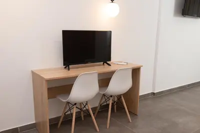 a desk with two chairs and a television on it at Evia Hotel in Athens