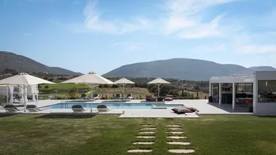 a house with a swimming pool with mountains in the background at Ema's Guest House in Porto Rafti