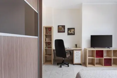 a room with a desk with a chair and a television at Ema's Guest House in Porto Rafti