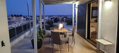 a room with a table and chairs on a balcony at The Penthouse in Athens