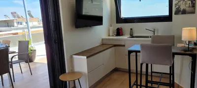 a kitchen with a table and a tv on the wall at The Penthouse in Athens