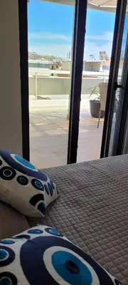 a bedroom with a bed with a view of a balcony at The Penthouse in Athens