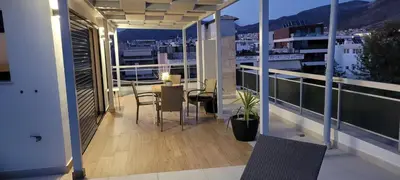 a balcony with a table and chairs on a building at The Penthouse in Athens