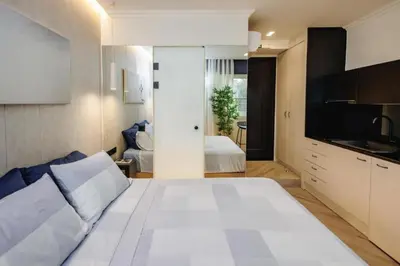 a bedroom with a large white bed and a kitchen at Triple A - Psiri Nightlife at Theatrou Square - Urban Studios - FREE Parking! in Athens