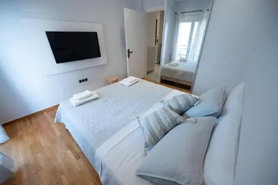 a bedroom with a white bed and a television at Athens Modern Hub in Athens