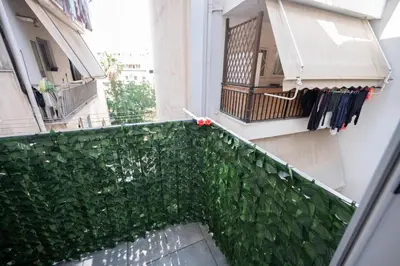 a balcony with a green hedge and a building at Athens Modern Hub in Athens