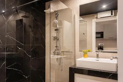 a bathroom with a shower and a sink and a mirror at WYZ Museum by UPSTREET in Athens
