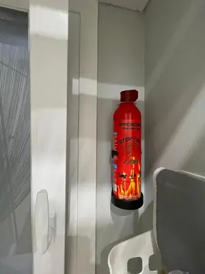 a red bottle is on the wall next to a toilet at FilOikos Privacy Nest Retreat 3Br 3Ba En-Suite in Athens