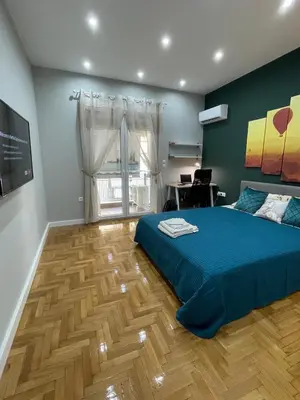 a bedroom with a blue bed and a wooden floor at FilOikos Privacy Nest Retreat 3Br 3Ba En-Suite in Athens