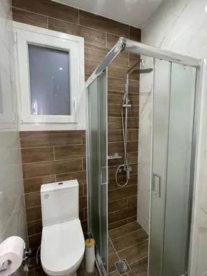 a bathroom with a toilet and a glass shower at FilOikos Privacy Nest Retreat 3Br 3Ba En-Suite in Athens