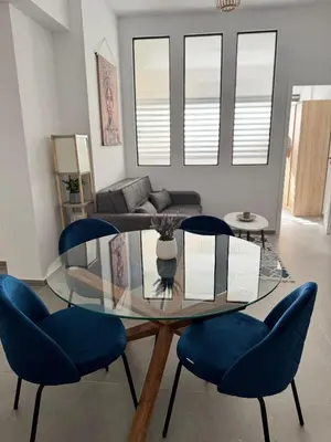 a dining room with a glass table and blue chairs at Heart of Athens Stay #6 in Athens