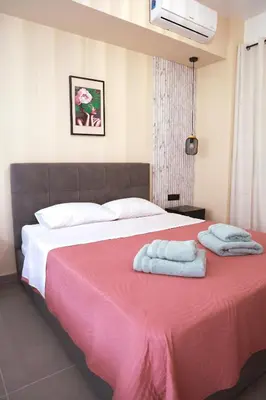 a bedroom with a pink bed with towels on it at Heart of Athens Stay #6 in Athens