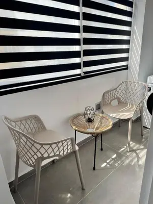 three chairs and a table in a room with a window at Heart of Athens Stay #6 in Athens