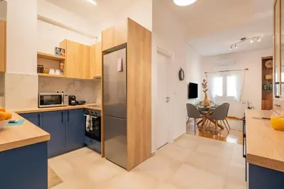 a kitchen with a stainless steel refrigerator and a table at Miss H Haven in Athens