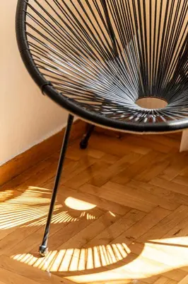 a black chair sitting on top of a wooden floor at Miss H Haven in Athens
