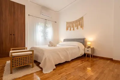 a white bedroom with a bed and a window at Miss H Haven in Athens
