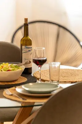 a table with a bottle of wine and a bowl of food at Miss H Haven in Athens