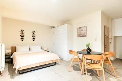 a bedroom with a bed and a table and chairs at Elysee apartment 1 in Athens