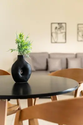 a black vase with a plant sitting on a table at Elysee apartment 1 in Athens
