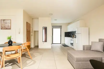 a kitchen and living room with a table and a couch at Elysee apartment 1 in Athens