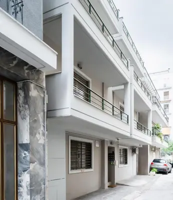 a white building with a balcony on the side of it at Elysee apartment 1 in Athens