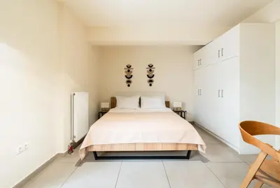 a bedroom with a large bed with white walls at Elysee apartment 1 in Athens
