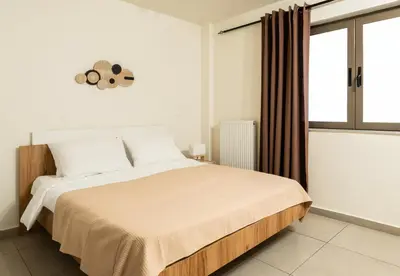 a bedroom with a large bed and a window at Elysee apartment 1 in Athens