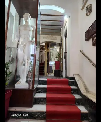 a statue of a man on a staircase with a red carpet at Sourmel Apt in Athens