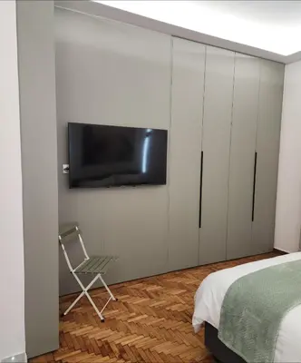 a bedroom with a bed and a tv on a wall at Sourmel Apt in Athens