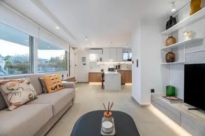 a living room with a couch and a kitchen at Glyfada Coastside Apartment in Athens