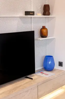 a flat screen tv sitting on top of a wooden entertainment center at Glyfada Coastside Apartment in Athens