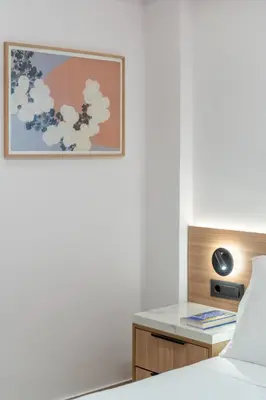 a bedroom with a bed and a desk with a picture on the wall at Glyfada Coastside Apartment in Athens
