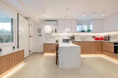 a kitchen with white cabinets and a counter top at Glyfada Coastside Apartment in Athens