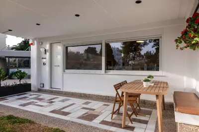 a patio with a wooden table and chairs at Glyfada Coastside Apartment in Athens