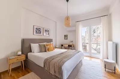 a bedroom with a large bed and a large window at Modern Athenian Nest near Kallimarmaro Stadium by UPSTREET in Athens