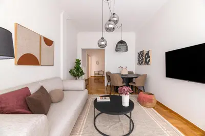 a living room with a couch and a table at Modern Athenian Nest near Kallimarmaro Stadium by UPSTREET in Athens