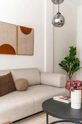 a living room with a couch and a table at Modern Athenian Nest near Kallimarmaro Stadium by UPSTREET in Athens